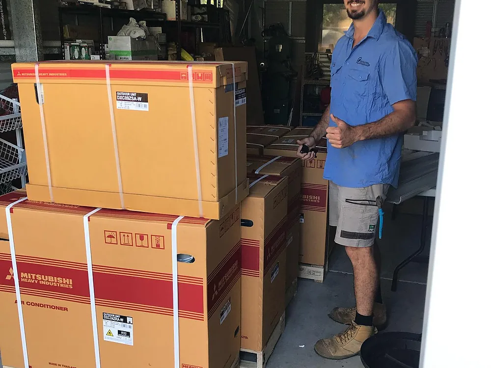 Watts & Volts electrician with boxed split system air conditioners ready for installation